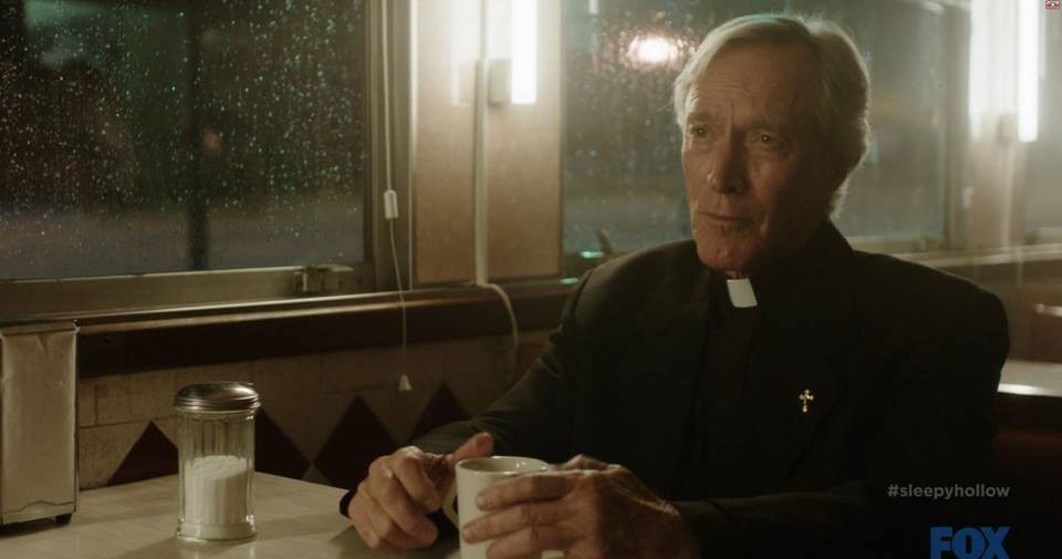 Reverend Alfred Kanpp (Patrick Gorman) sitting in a diner on Sleepy Hollows