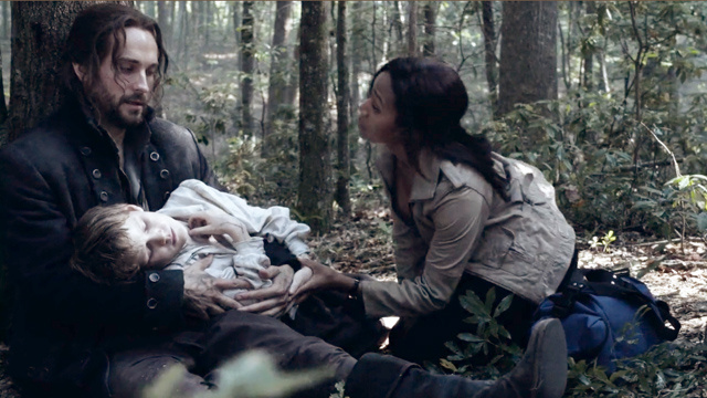 Ichabod (Tom Mison) and Abbie (Nicole Beharie)n tend to a sick boy on Sleepy Hollow