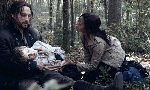 Ichabod (Tom Mison) and Abbie (Nicole Beharie)n tend to a sick boy on Sleepy Hollow